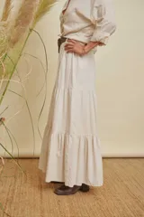 Pollera larga color beige, de corte holgado con volados en la parte inferior.