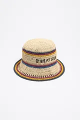Gorro tipo bucket de rafia tejida en color beige natural, con franjas decorativas en azul, bordó y amarillo. El texto "BIMBAYOLA" está bordado en negro en la parte frontal.