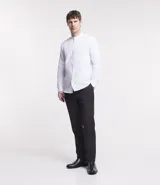 Camisa blanca de corte regular, confeccionada en tela Oxford de algodón, con cuello tipo padre, mangas largas y abotonadura frontal.