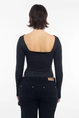 Body negro de algodón con escote barco y mangas largas.
