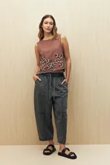 Pantalón gris oscuro de denim con corte holgado, cintura elastizada con cordón y ruedo con dobladillo.