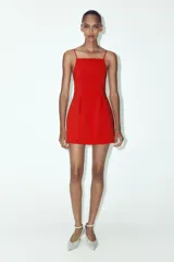 Vestido corto rojo de escote cuadrado con tirantes finos ajustables, detalle de pliegues en delantero y espalda, forro interior y cierre en espalda con cremallera oculta en costura.