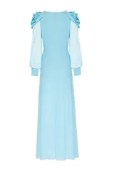 Vestido largo de chiffon azul, con flores de tela en los hombros, manga larga y escote cruzado.