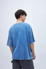 Remera celeste con efecto marmolado y estampa en el pecho, de corte boxy y mangas cortas.