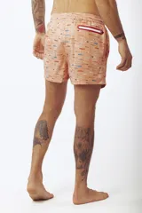 Short de baño estampado con motivos de hojas tropicales en tonos verde, beige y naranja.
