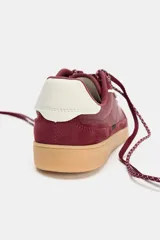 Zapatillas deportivas color borgoña con suela color caramelo y detalles en blanco.