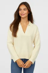 Sweater color crema de poliéster, corte relaxed y cuello en V.