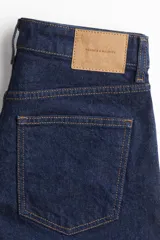 Short de denim azul oscuro, de tiro alto, con cinco bolsillos y cierre con botón.