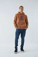 Buzo canguro color marrón con capucha ajustable, bolsillo canguro, fit regular, arte estampado en relieve y logo en goma.