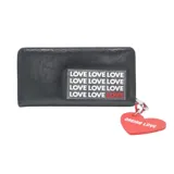 Billetera negra de cuero sintético con cierre, estampado con la palabra "LOVE" repetida en el frente y dije colgante en forma de corazón rojo con la inscripción "OREIRO LOVE".