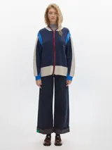 Campera tejida con cierre delantero, bordado en la espalda, de color rojo con detalles marrones y grises.