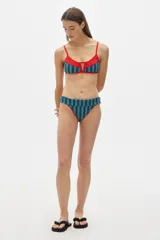 Conjunto de bikini rojo con rayas verticales azules y verdes. El corpiño es de corte triangular con breteles finos y abertura en el centro. La bombacha es de corte clásico con cintura ancha.