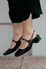 Zapatos estilo Mary Jane color beige, confeccionados en cuero, con taco cuadrado de 6 cm y tira con hebilla sobre el empeine.