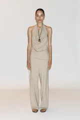 Pantalón de algodón color beige, de corte amplio y tiro alto, con cintura elástica ajustable con cordones y bolsillos laterales.