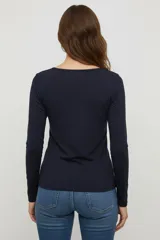 Remera negra de manga larga, confeccionada en algodón y elastano, corte ajustado al cuerpo y cuello redondo.