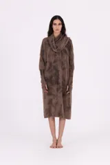 Vestido de tejido de punto color marrón con efecto tie-dye o desteñido en tonos más oscuros. Presenta cuello tortuga caído y mangas largas con abertura para el dedo. El calce es amplio y el largo es midi.