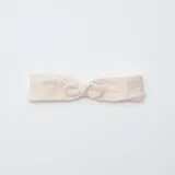 Diadema de tela color rosa claro con nudo y elástico.