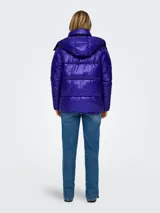 Campera puffer azul eléctrico con capucha, cierre frontal con cremallera, bolsillos laterales con solapa y puños con elástico. Diseño acolchado y corte holgado.