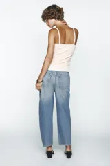 Pantalón de jean celeste de corte amplio, con tiro medio, cinco bolsillos y costuras torcidas.