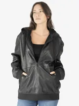 Chaqueta oversize tipo sudadera con capucha, confeccionada en cuero negro, con cierre frontal y bolsillos laterales.
