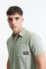 Remera polo negra con bolsillo de nylon en el pecho y logo bordado. Corte regular.