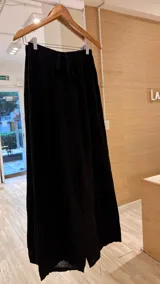 Pantalón negro de lino, corte ancho, con cintura elástica y bolsillos laterales.