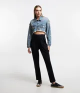 Campera cropped de jean celeste con cuello solapa, cierre frontal con botones, mangas largas, barra deshilachada con flecos y detalles de roturas.