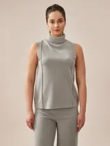 Polera gris melange de tejido de punto con cuello alto y sin mangas.