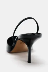 Zapato destalonado de charol negro con escote en pico, tira trasera ajustable y tacón fino.