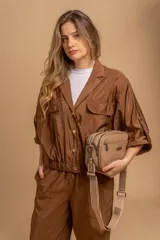 Bandolera color mostaza de simil cuero, con tres cierres principales, cierre delantero y bolsillo trasero. Incluye correa ajustable.