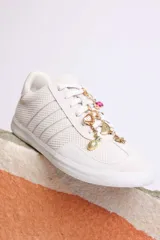 Zapatillas bajas de gamuza celeste con cordones y pañuelos estampados atados a los cordones.