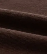 Pantalón masculino negro de corte baggy, confeccionado en sarga de algodón. Presenta detalles de costura, cierre tradicional de botón y cremallera, y un cordón blanco para ajustar la cintura.