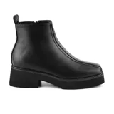 Bota corta color marrón con plataforma y taco bajo. Presenta detalle de costuras en la parte delantera y cierre lateral.