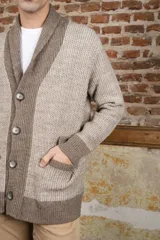 Cardigan tejido color marrón con cuello smoking, cierre con botones y bolsillos delanteros.