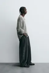 Pantalón de jean negro de corte amplio, estilo balloon fit, con cinco bolsillos y cierre frontal con botones.