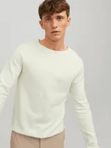 Sweater de punto color crema, de manga larga y cuello redondo.