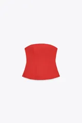 Top rojo de escote recto y hombros descubiertos, con corte peplum y cierre lateral con cremallera oculta.