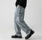 Pantalón de jean azul claro lavado, estilo cargo y corte ancho (baggy), con cintura elástica ajustable y bolsillos cargo laterales.