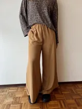 Pantalón palazzo color beige con cintura elástica y bolsillos laterales.