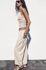Pantalón ancho color beige, de tiro medio y cintura ajustable con cordones.