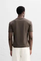 Camiseta slim fit de cuello redondo y manga corta, confeccionada en tejido de algodón con elasticidad.