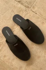 Pantuflas cerradas de cuero sintético negro con logo VDM en el lateral.