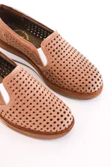 Panchita de cuero color beige con diseño calado, suela blanca y elástico en los laterales.