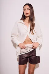 Camisa oversize color crudo, confeccionada en lino y viscosa, con cuello clásico, cierre frontal con botones de nácar y manga larga.