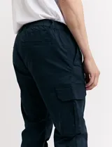 Pantalón cargo verde con bolsillos laterales, corte slim fit y tobillos elastizados.