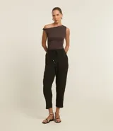 Pantalón fluido de cintura alta, confeccionado en crepé, con elástico y lazo en la cintura. Presenta un estampado geométrico con líneas curvas horizontales.