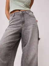 Pantalón jean gris de corte ancho, estilo baggy, con bolsillos delanteros y traseros.