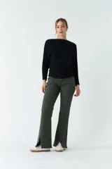 Sweater verde de punto liviano con textura acanalada y diseño de hombros caídos.