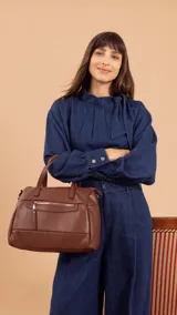 Cartera negra de simil cuero con correa corta y correa larga ajustable. Tiene cierre principal, bolsillos interiores y exteriores en la parte delantera y trasera.