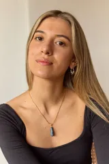 Collar dorado con cadena fina y dije colgante en forma de lágrima de piedra natural azul con vetas blancas.